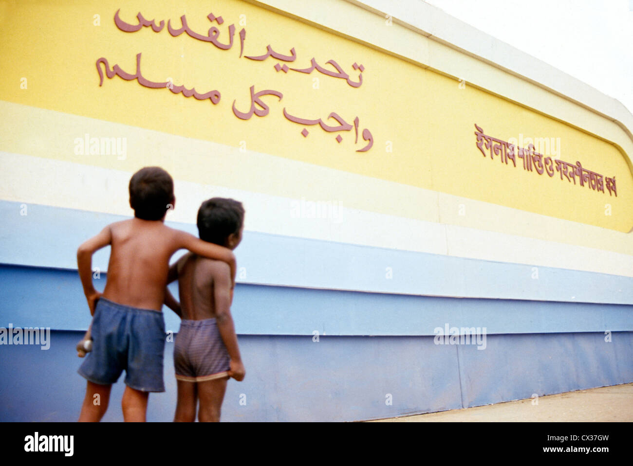 Bangladesh Boys Reading A Billboard In Arabic And Bengali Stock Photo Alamy