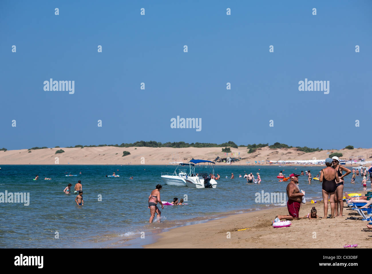 Tourists sunbath on the beach of Agios Georgios, Corfu, Ionian Islands, Greece. Stock Photo