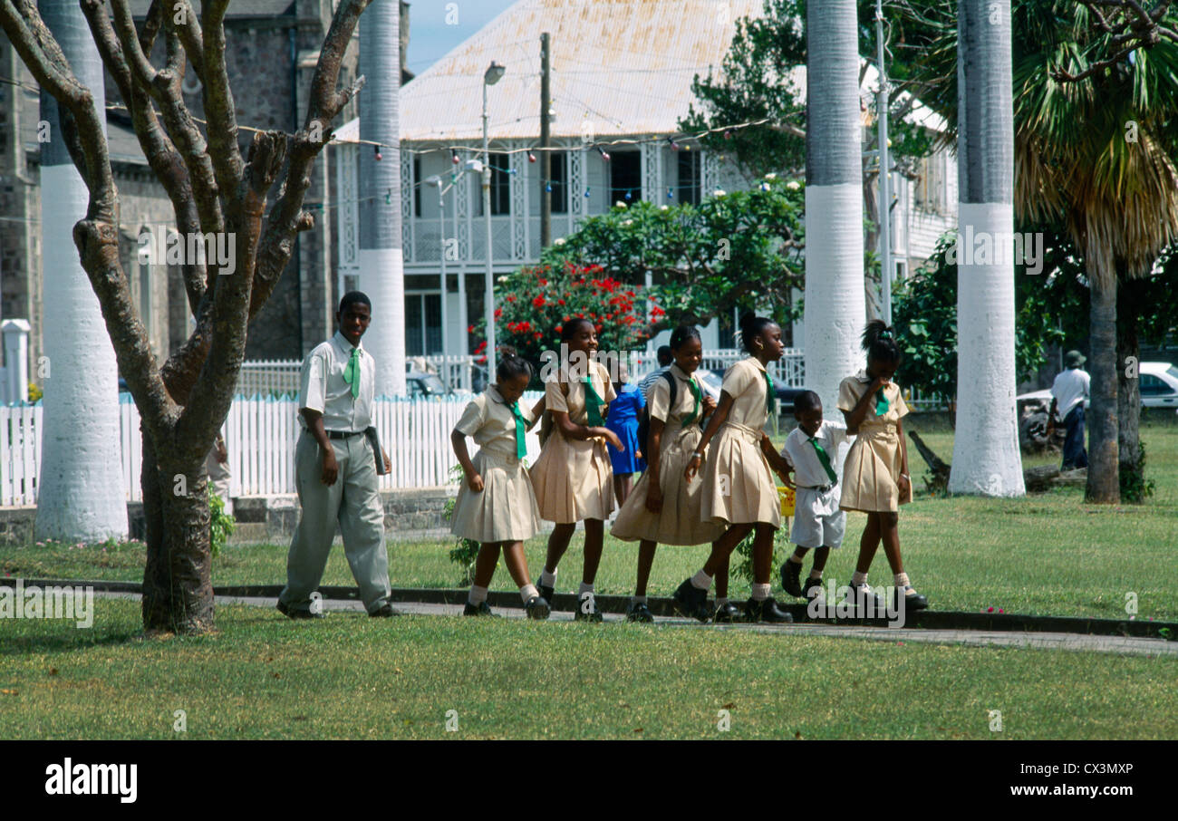 Basseterre St Kitts A Group Of School Children Walking Across Park Talking And Giggling Stock Photo