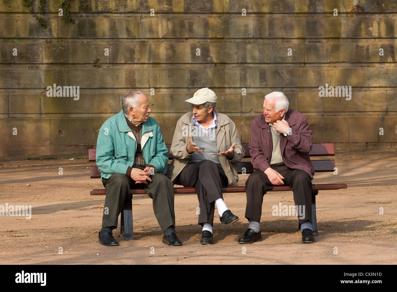 three 3 old men friends talking arguing discuss Stock Photo