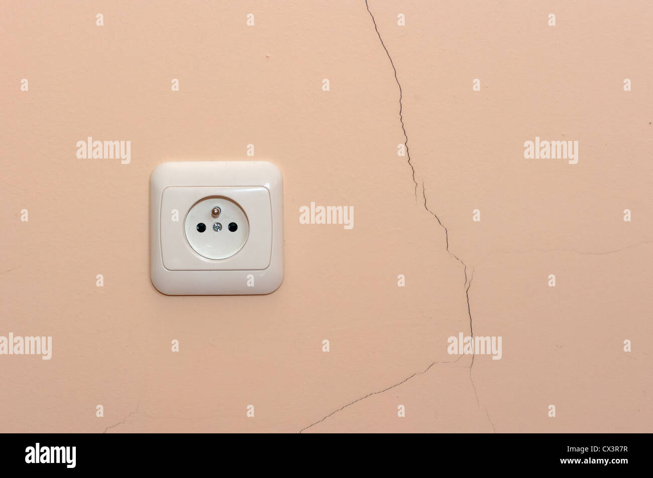 A crack in the wall next to an electrical outlet Stock Photo Alamy