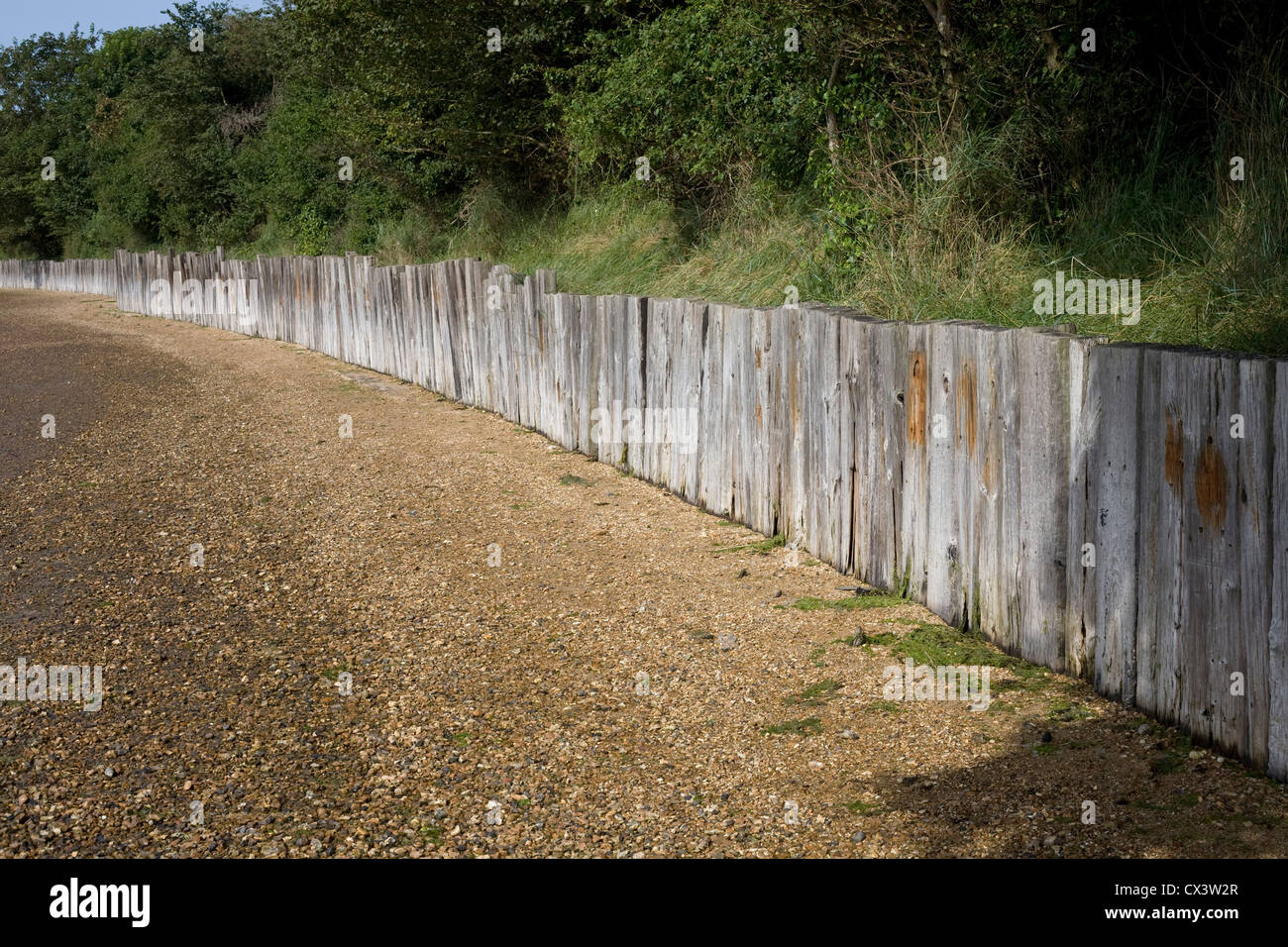 pebble beach at Langstone, Havant, with old railway sleepers as wall Stock Photo