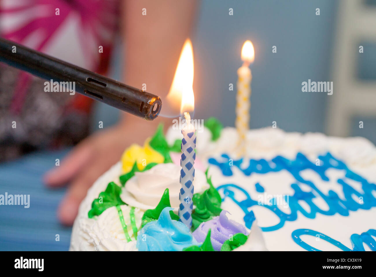 Lighting candles on a birthday cake Stock Photo - Alamy