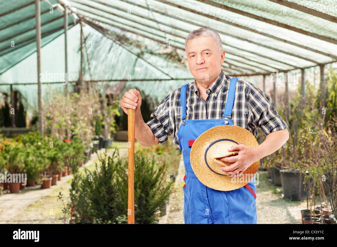 Male worker holding a shovel and posing in a flower garden Stock Photo ...