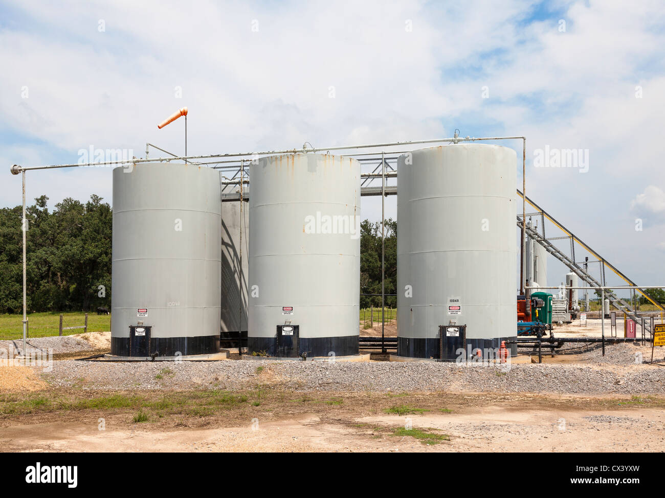 Oil storage tanks for holding crude oil to be loaded in tanker trucks at a remote crude oil well site Stock Photo