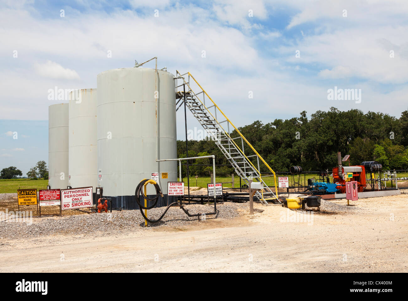Remote crude oil pumping and truck loading facility for rural oil wells, view of storage tanks and pumps. Stock Photo