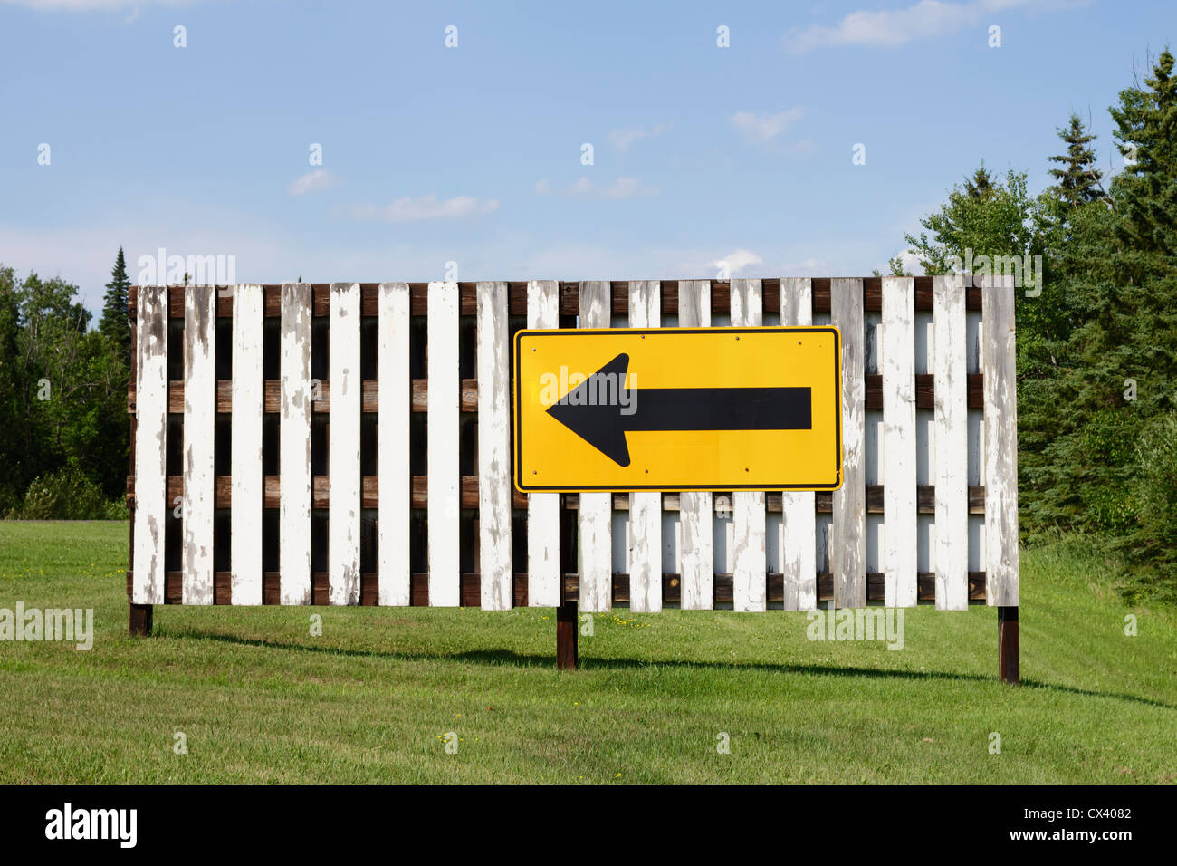 Directional arrow sign on a white fence Stock Photo - Alamy