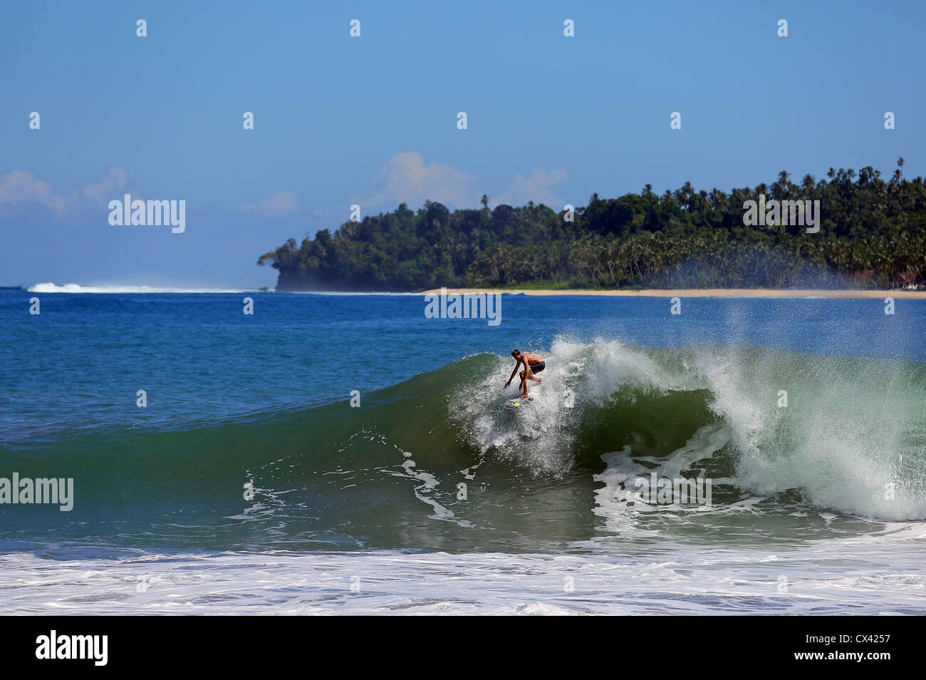 Australian surfer surfing a beach break wave in Sumatra, Indonesia. Stock Photo