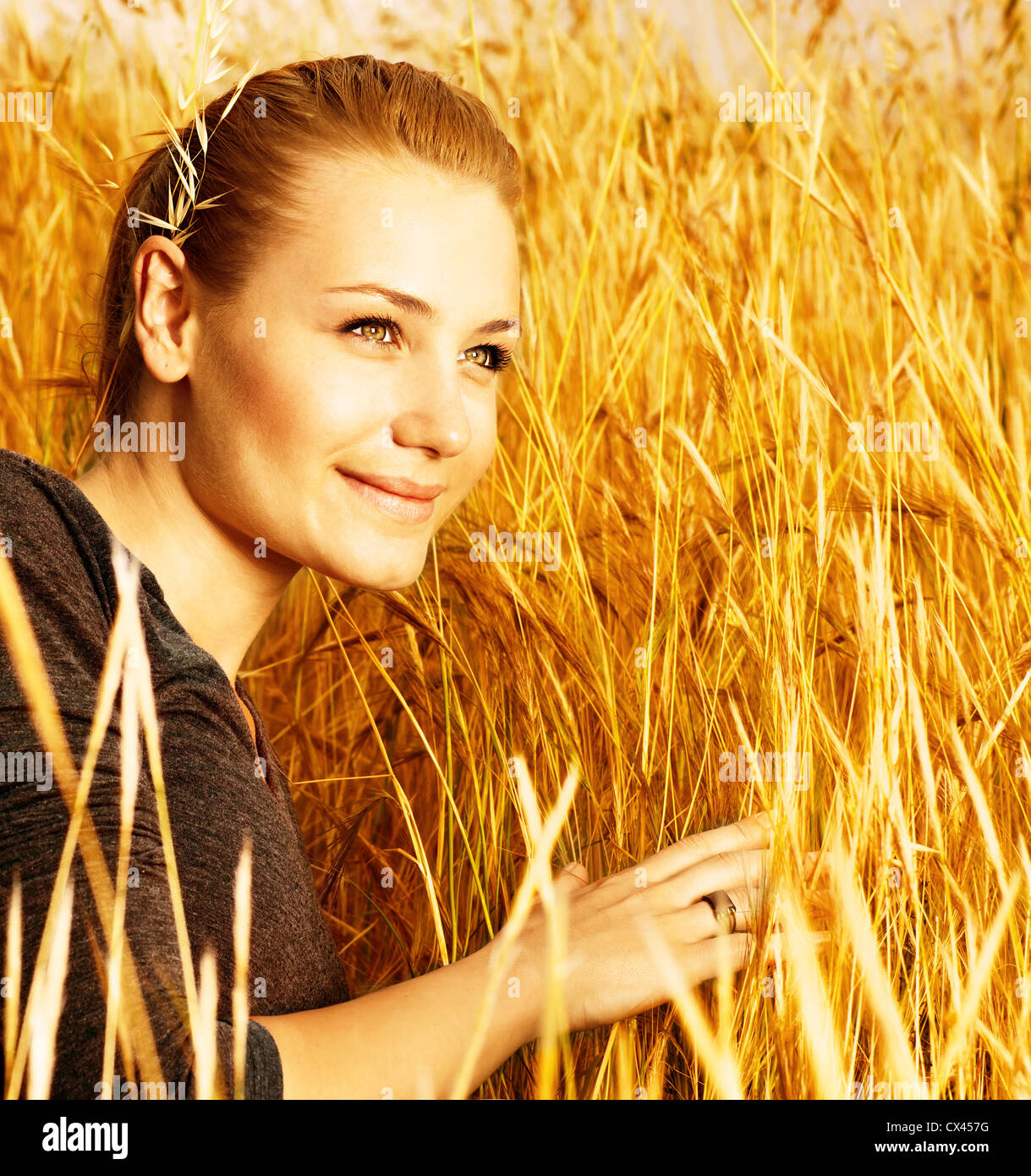 Photo Of Attractive Smiling Girl Sitting In Golden Wheat Field Closeup