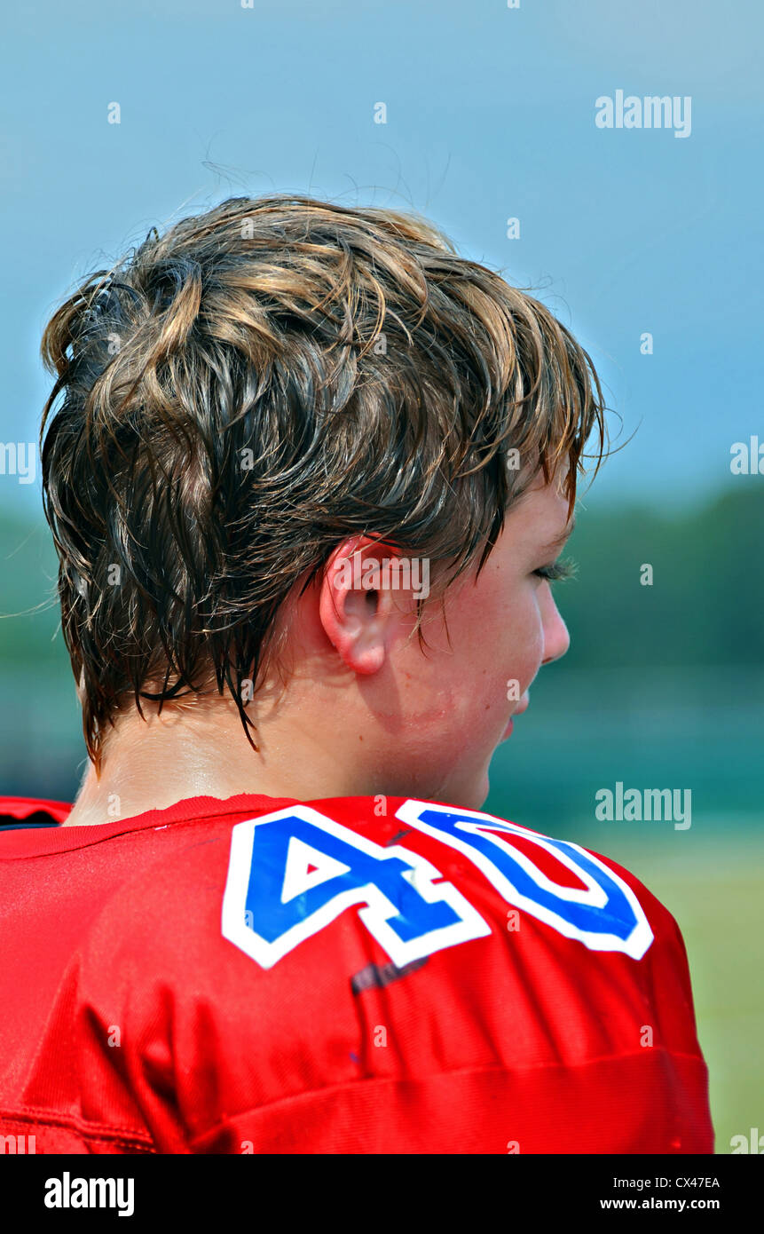 Preteen football player watching action on the field. Stock Photo