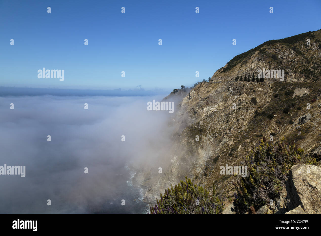 Highway 1 winds high above the Pacific Ocean fog bank in Big Sur, California Stock Photo