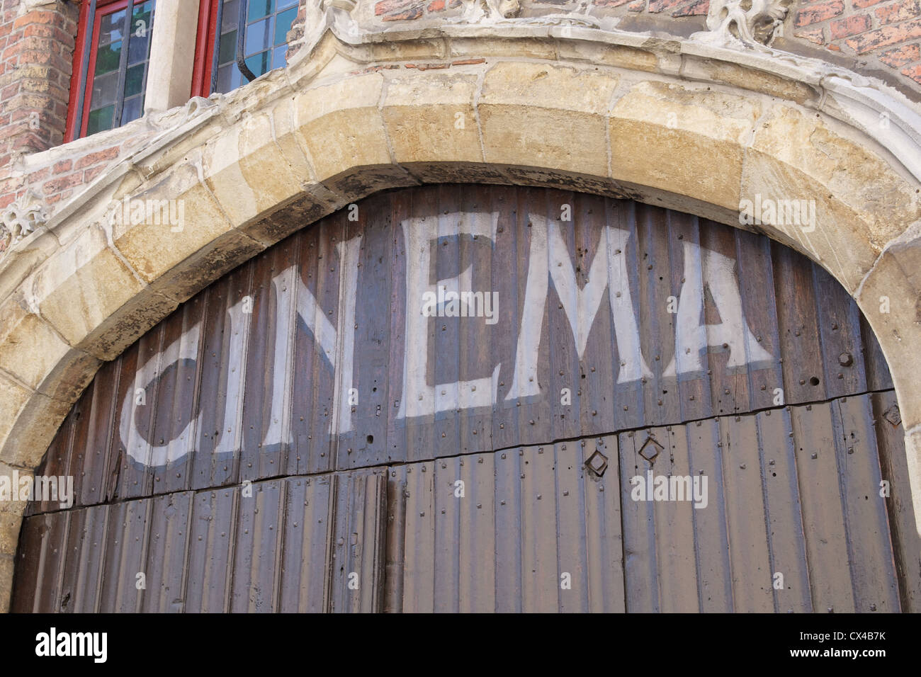 The entrance to an old classic cinema in Belgian city of Bruges. The word cinema is painted on the old wooden door Stock Photo