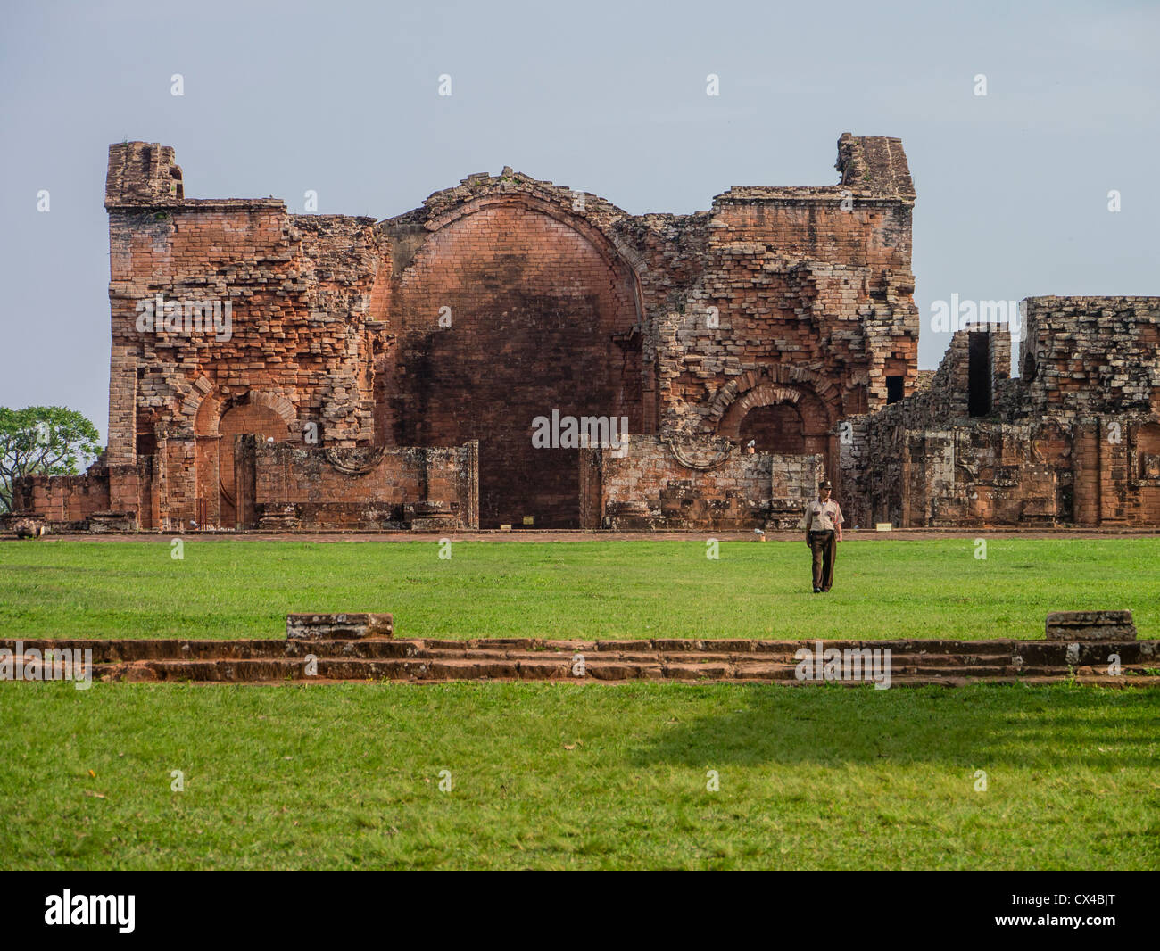 A guard stands in the main plaza in front of the ruins of the famous Jesuit reduction located at  Trinidad, Paraguay. Stock Photo
