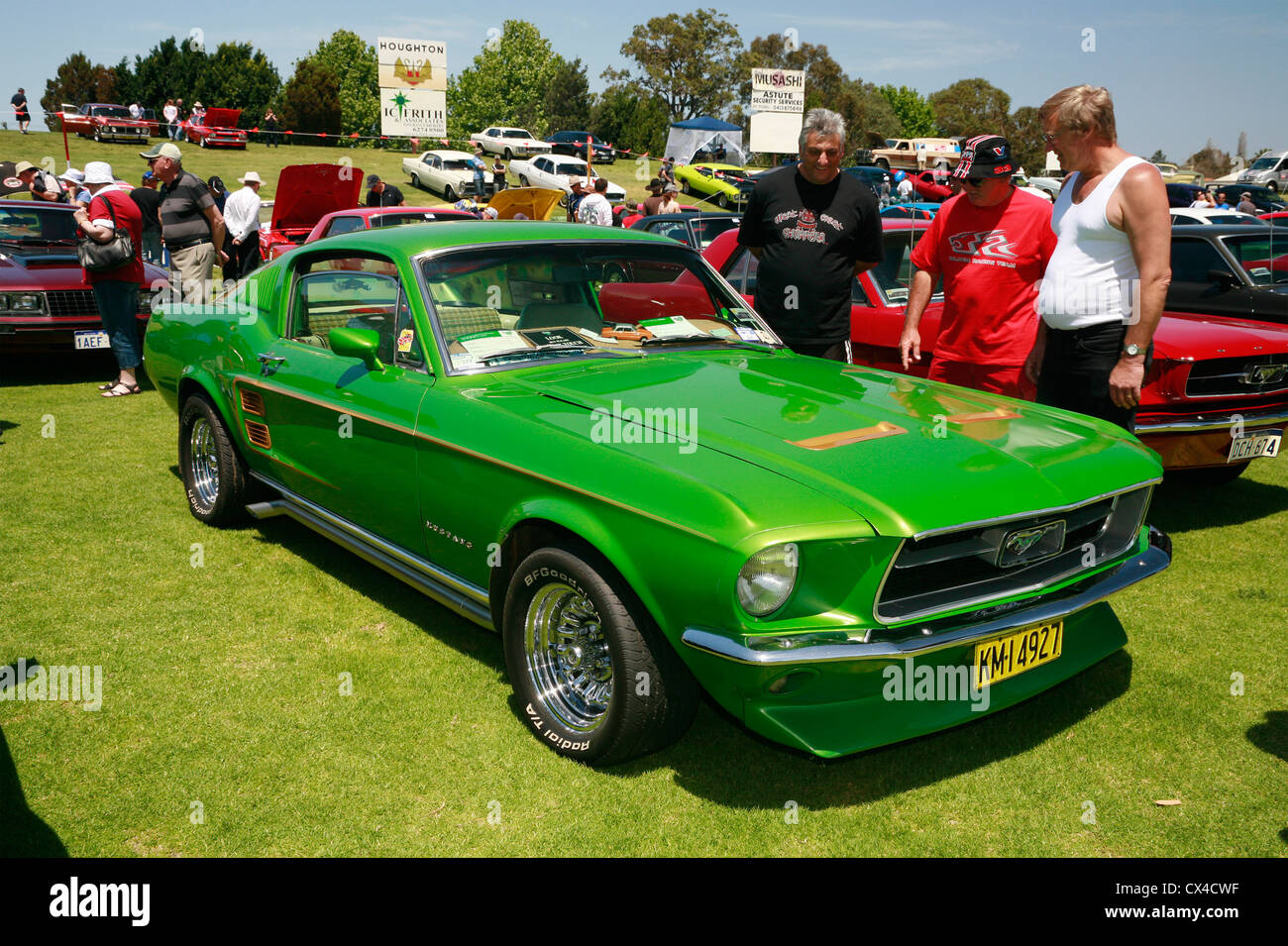 Car enthusiasts admiring a modified 1967 Ford Mustang Fastback at an outdoor Australian car show. Stock Photo