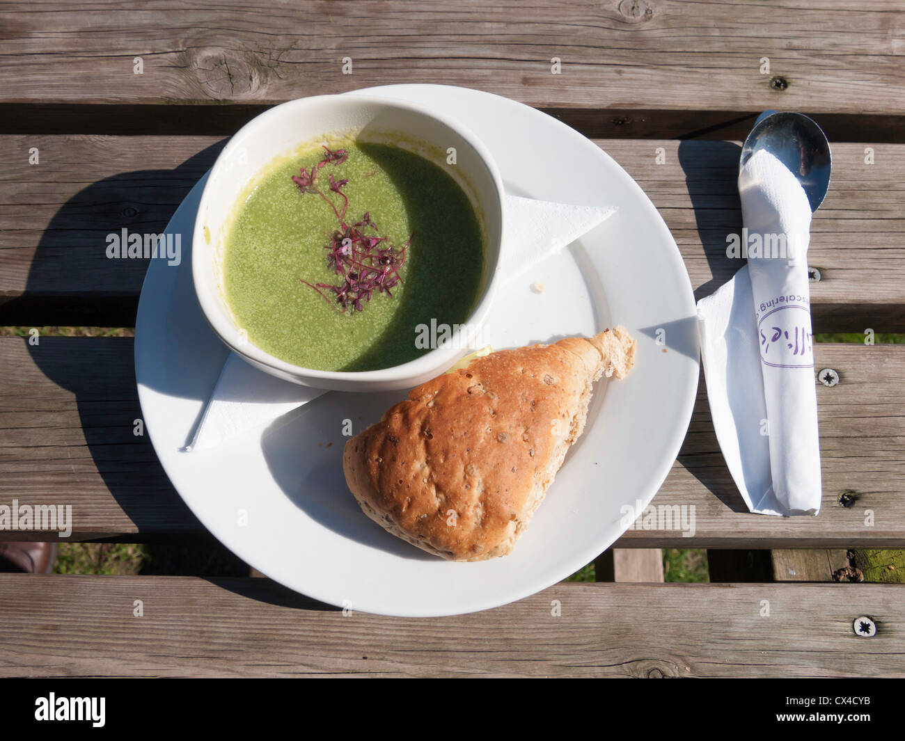 A slimmers lunch of broccoli soup and a piece of bread at an outdoor café table Stock Photo