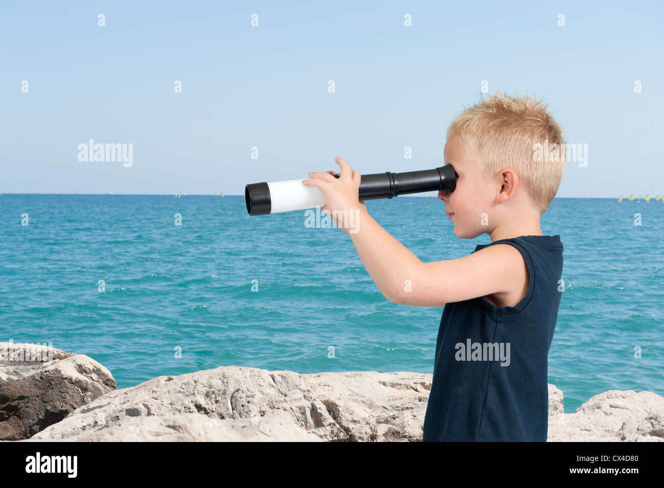 boy with spyglass at the beach Stock Photo