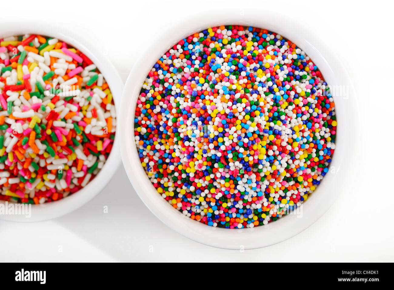 sugar spreading and rainbow sprinkles in cup Stock Photo