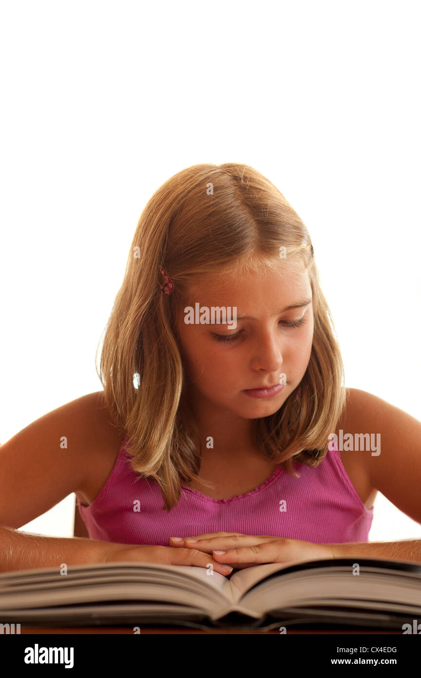 8-9 year girl reading or studying a book at the table Stock Photo