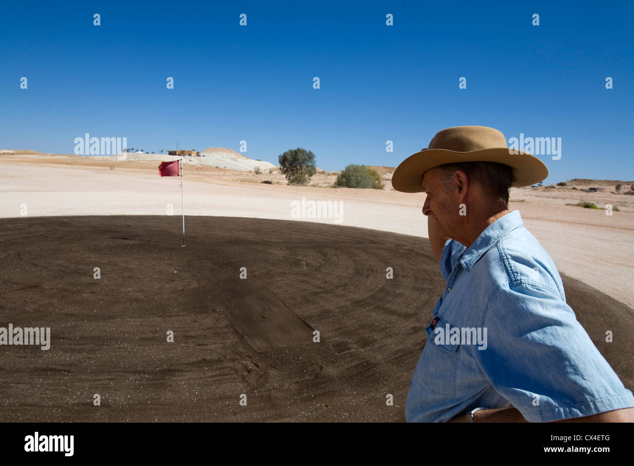A man inspects a puttting green on the Coober Pedy golf course.  Coober Pedy, South Australia, AUSTRALIA Stock Photo