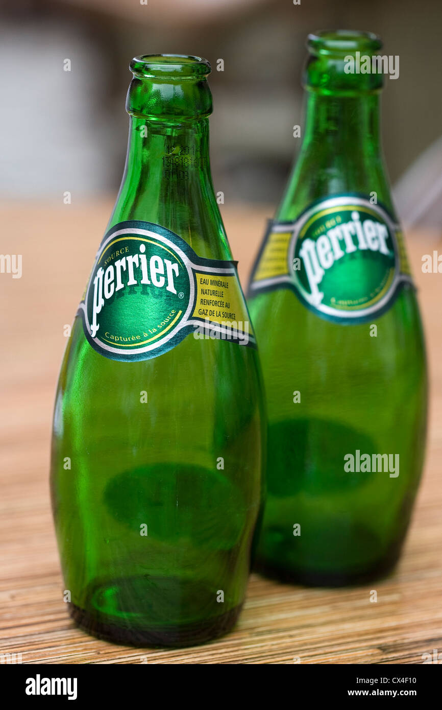 Two Perrier bottles on a French cafe table. Stock Photo