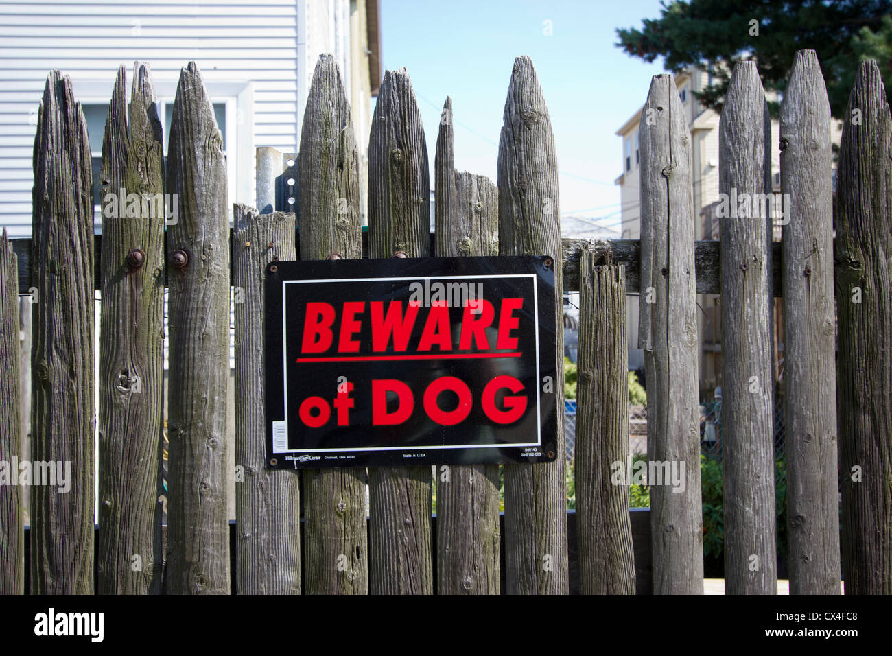 Beware of Dog sign posted on an old weathered wooden stockade fence Stock Photo