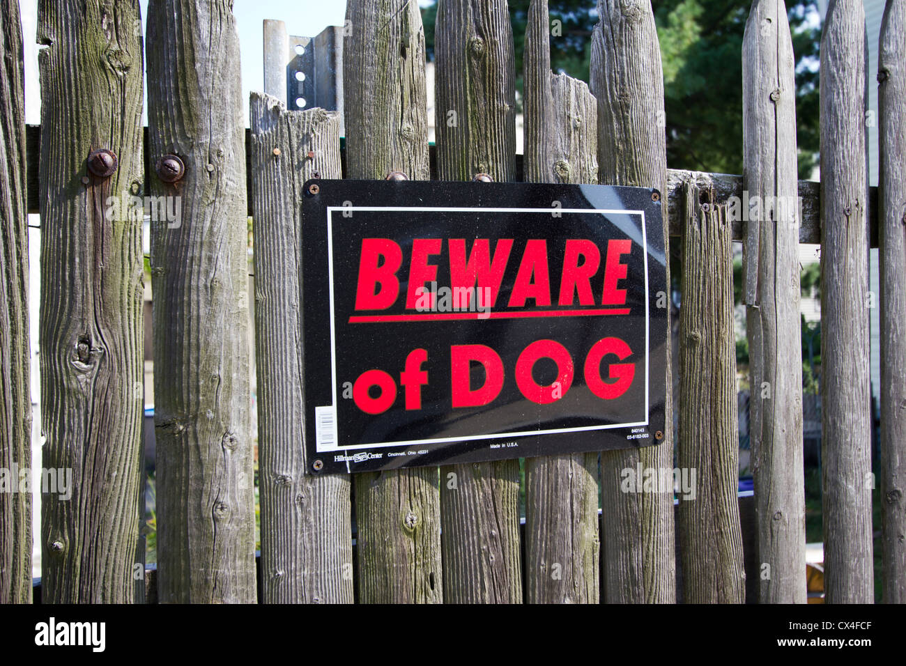 Beware of Dog sign posted on an old weathered wooden stockade fence Stock Photo