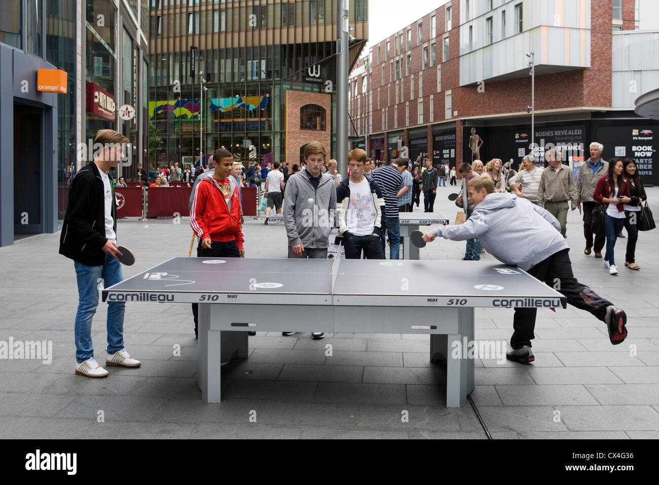 Street furniture sport,Teenagers playing outdoor table tennis at Liverpool One, UK Stock Photo