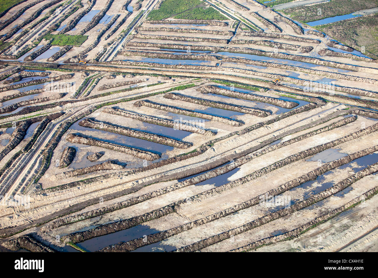Soil overburden being removed to get at the tar sands below, in a mine