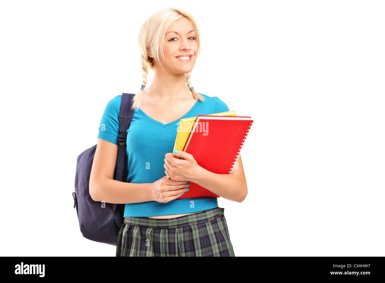 A smiling school girl walking and holding books isolated on white ...