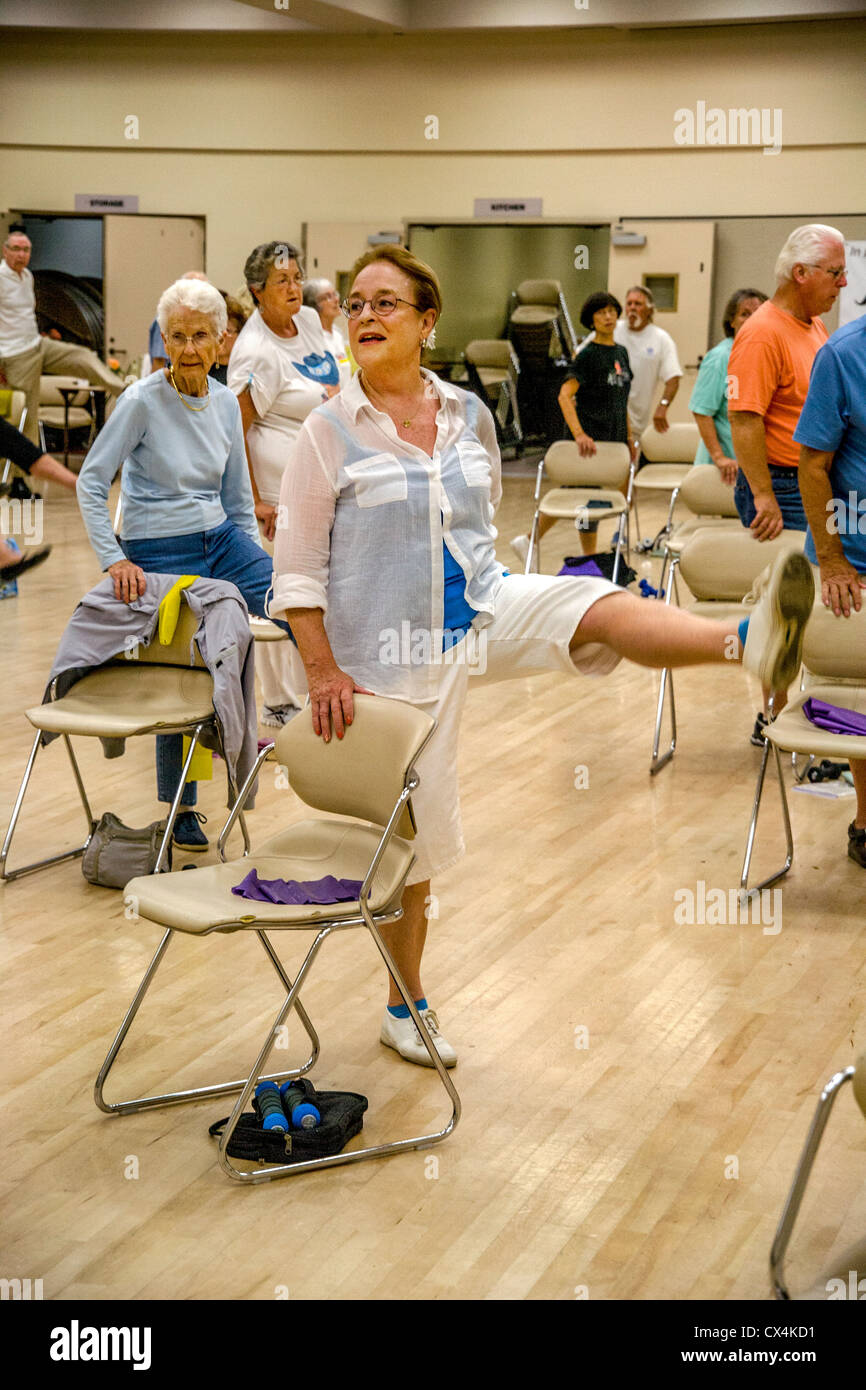 Senior women and men work out during a chair exercise class at a senior