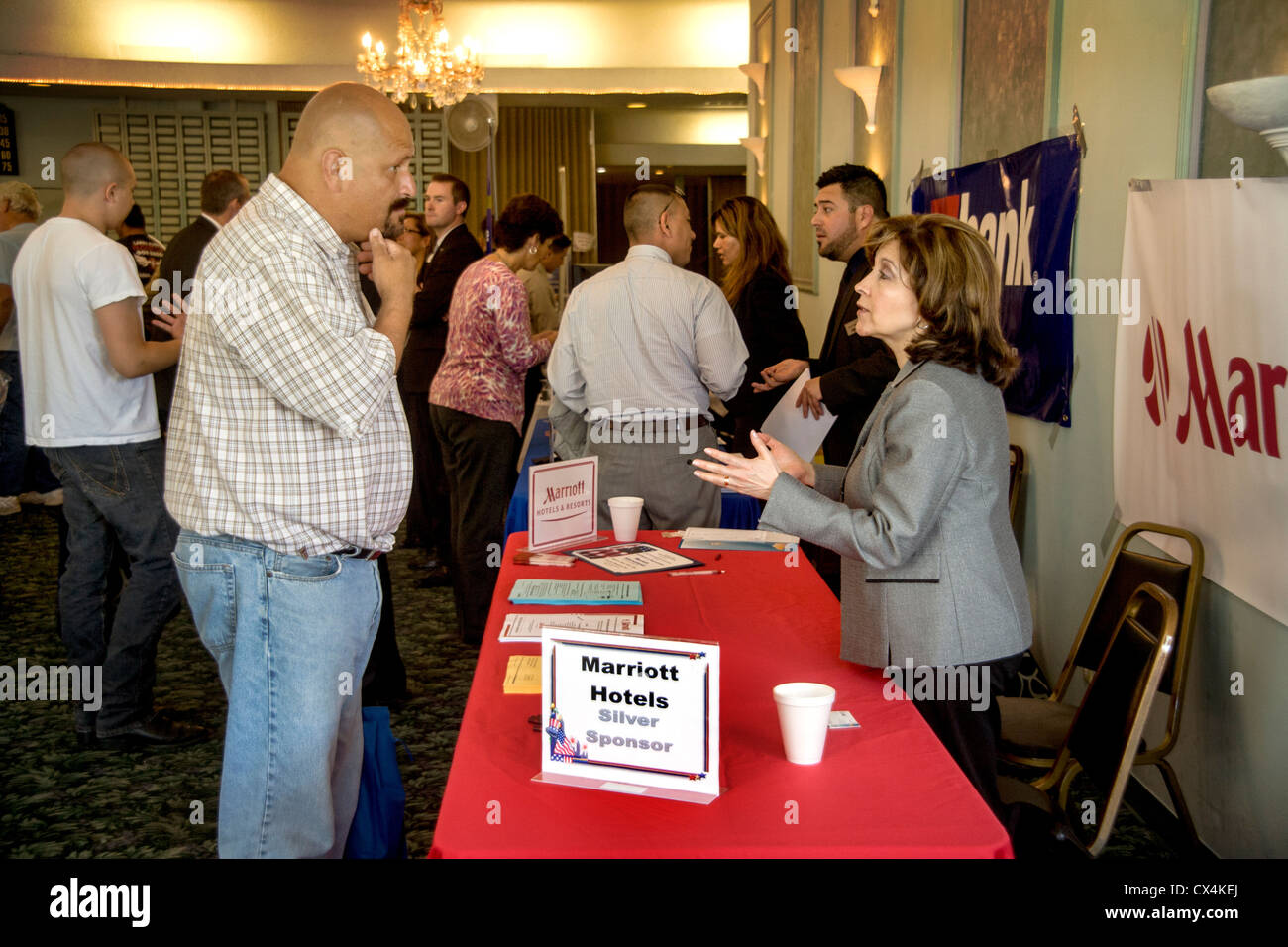 A skeptical Hispanic man considers hotel employment at a job fair for military veterans in Santa Ana, CA. Stock Photo