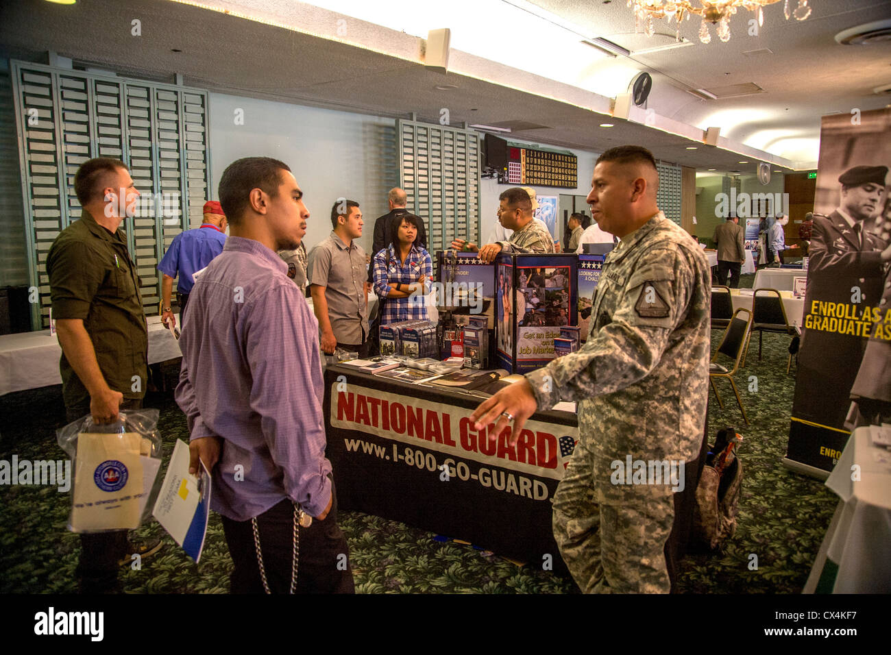 A young Hispanic man talks with a U.S. Army National Guard recruiter at a job fair for military veterans in Santa Ana, CA. Stock Photo