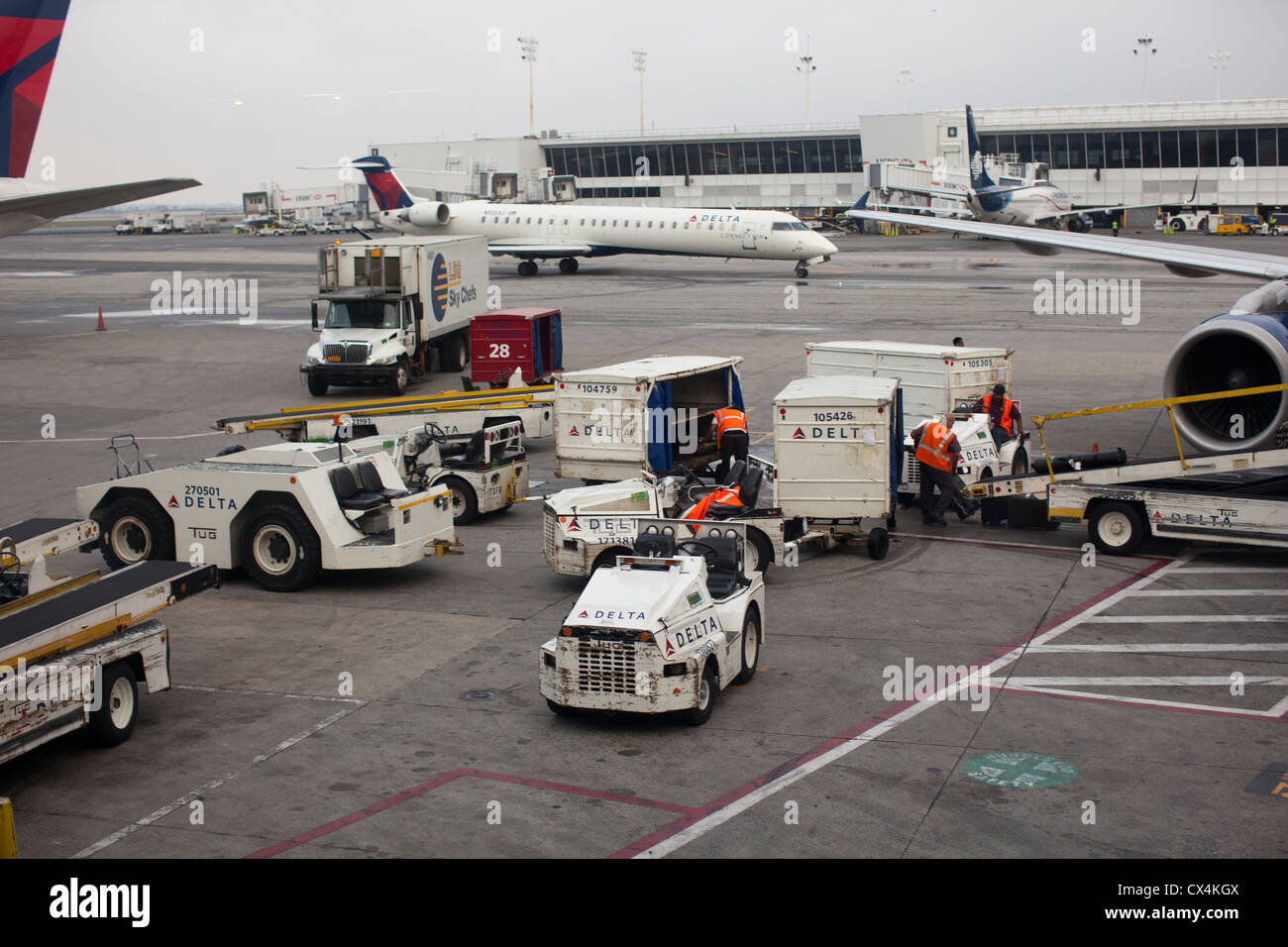 A Delta Air Lines ground crew loads luggage onto a jet airplane at the