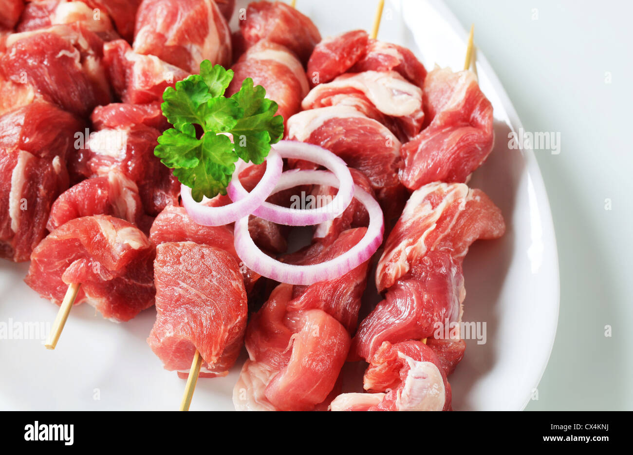 Raw pork skewers on plate Stock Photo Alamy