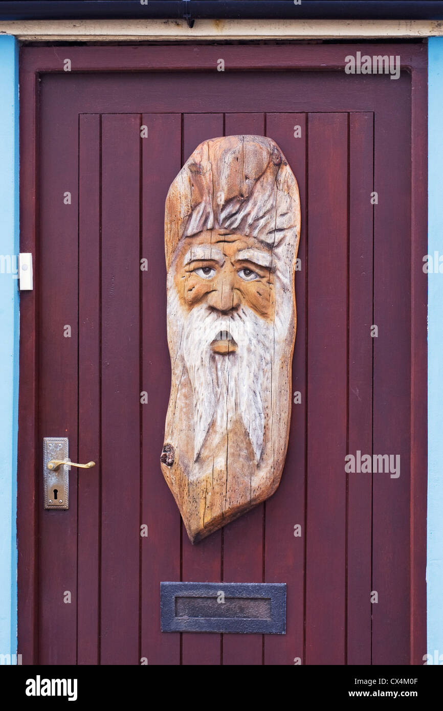 Woodcarving on the door of a house in Ravenglass. Stock Photo