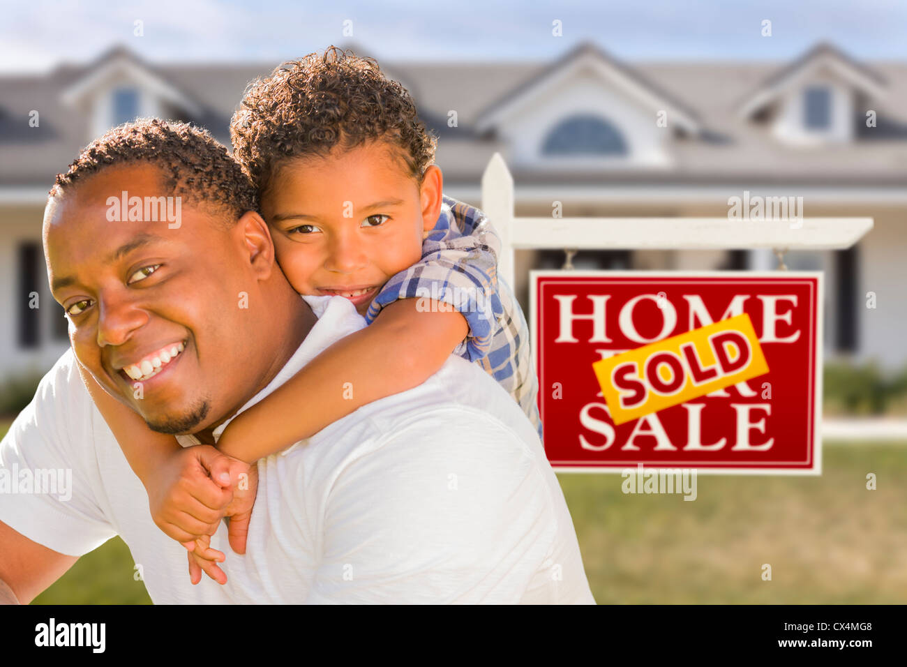 Happy Mixed Race Father and Son In Front of Sold Real Estate Sign and ...