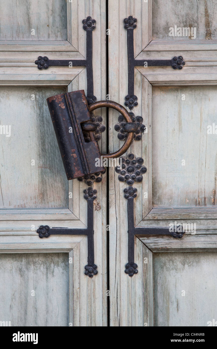 Old style / antique iron lock on an ornate wooden door in the