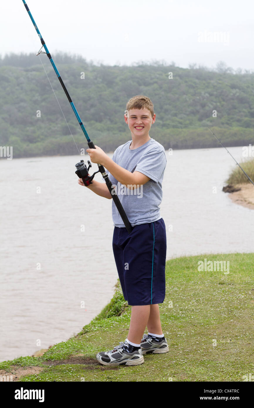 happy teen boy fishing by the lake Stock Photo Alamy