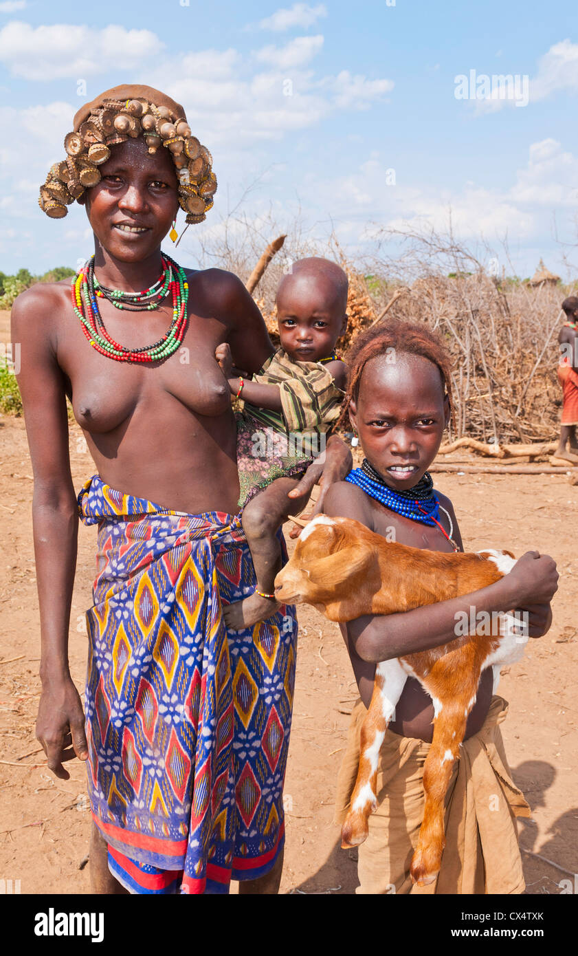 Dassnech Tribe in Omorate Ethiopia Africa Lower Omo Valley wife with  children nude topless in village with headress #26 Stock Photo - Alamy