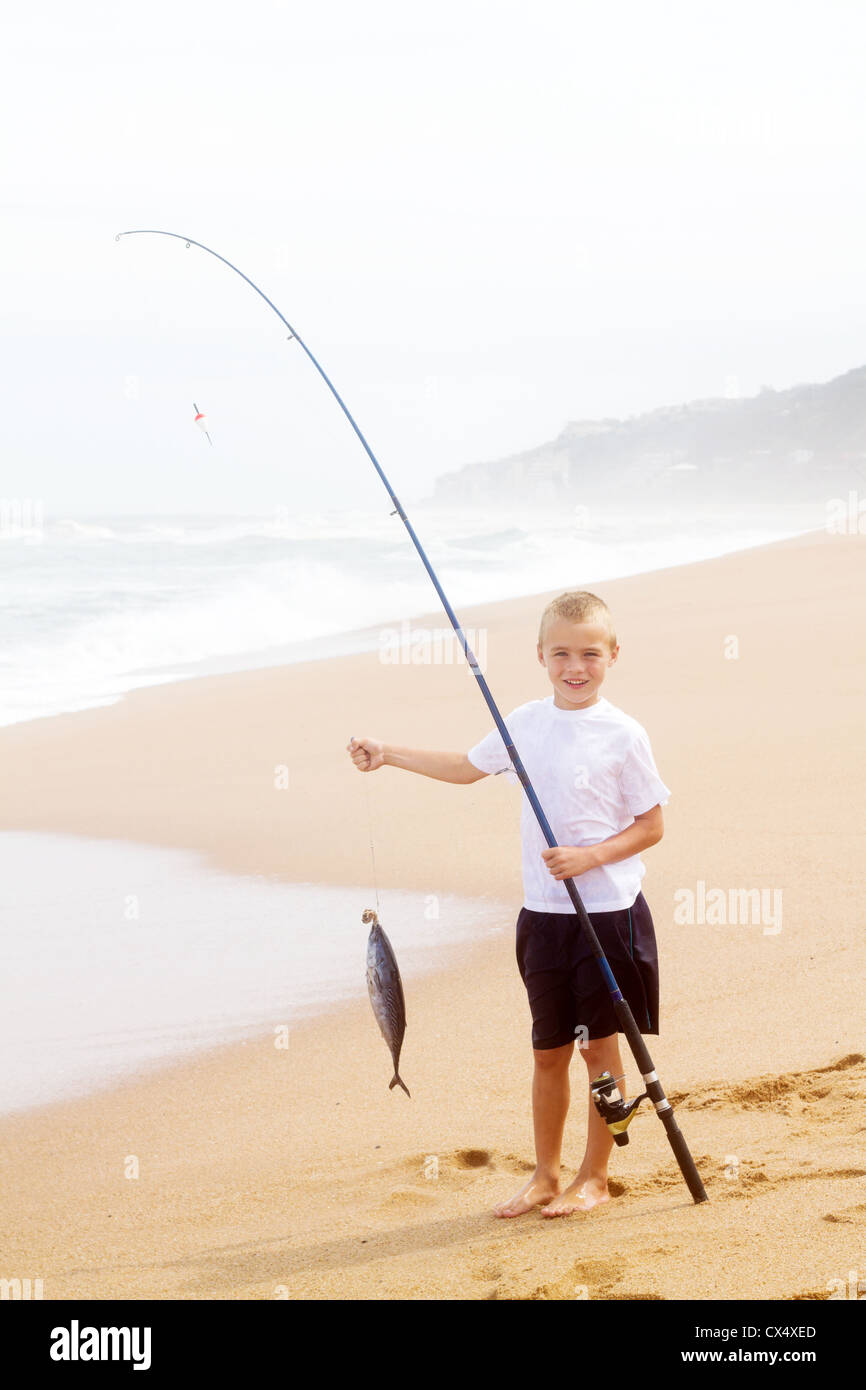 little boy catching a big fish on beach Stock Photo Alamy