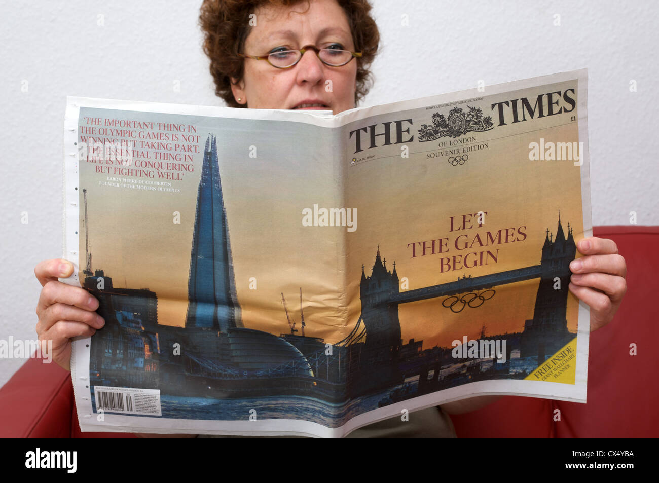Woman reading The Times souvenir edition 'Let the games begin' headline Stock Photo