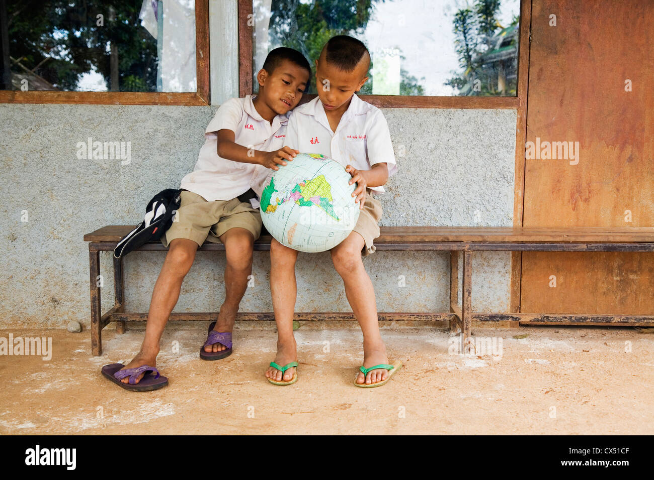 Thai schoolchildren studying a world globe. Mae Hong Son, Mae Hong Son, Thailand Stock Photo