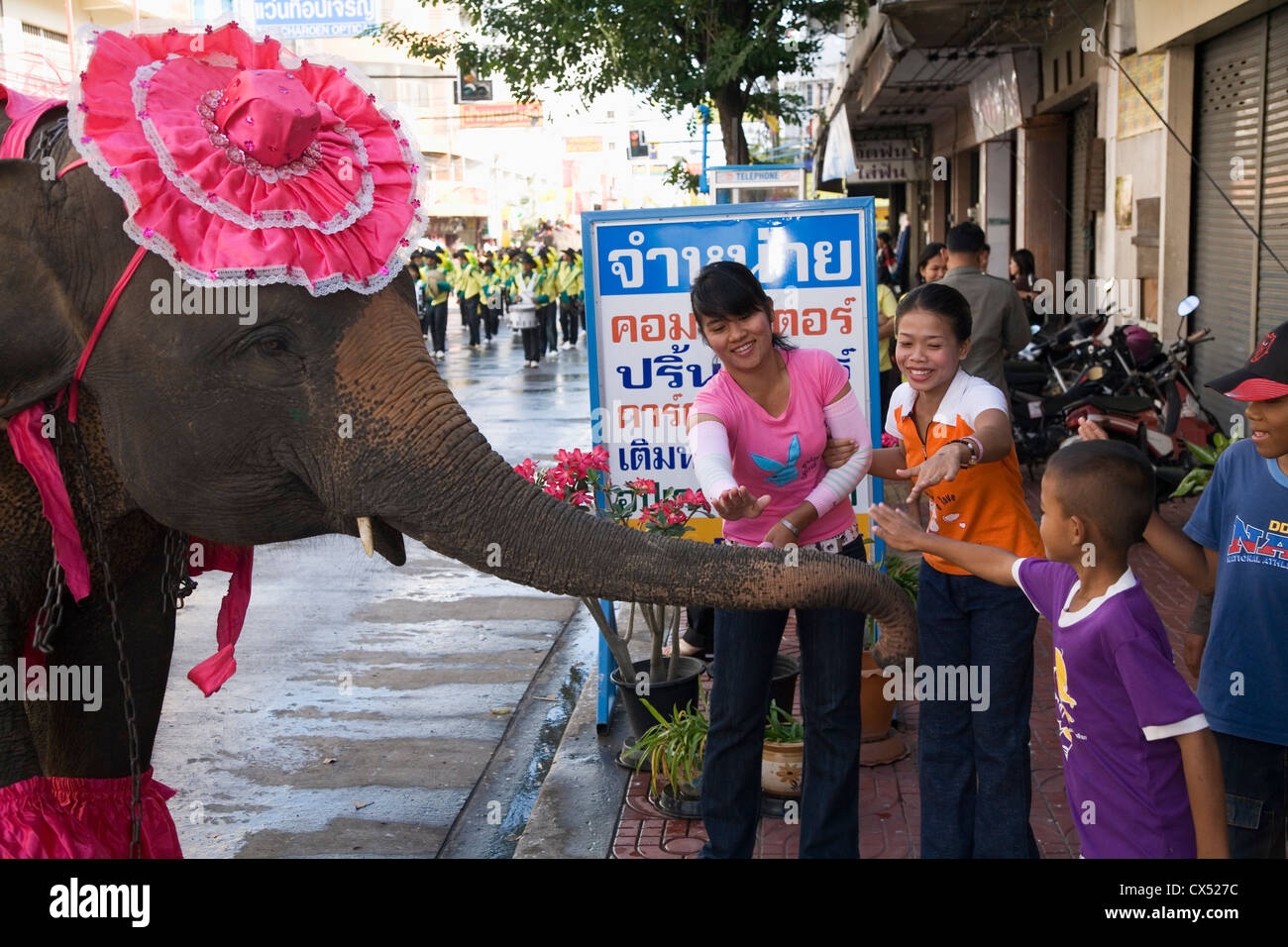 Local children greet the elephant parade during the annual Elephant Round-up festival.  Surin, Surin, Thailand Stock Photo