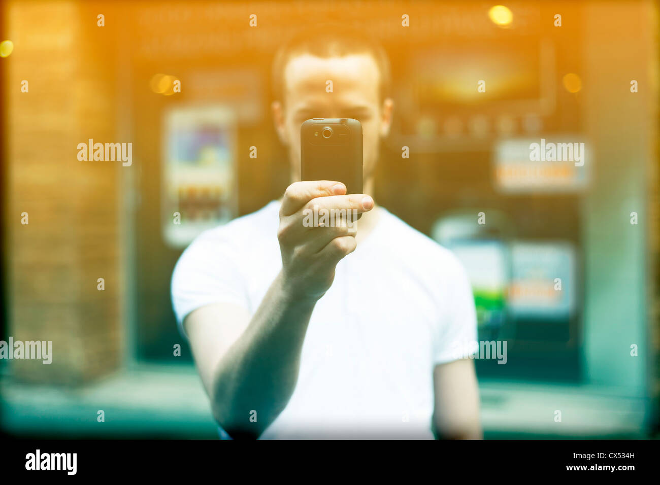 Men on street photographing with smartphone, background is blured city ...