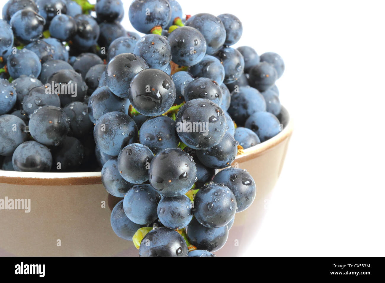 wet red grapes in brown bowl Stock Photo