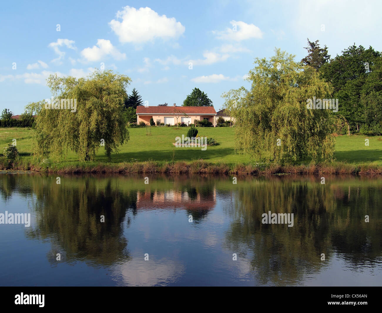 Landscape of a french property with an house reflected in a pond Stock Photo