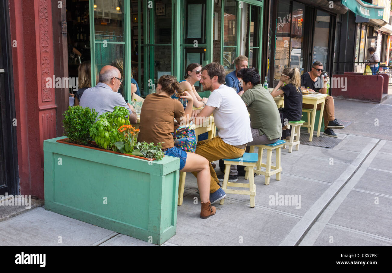 People enjoying an alfresco lunch at a wine bar on Mott Street in