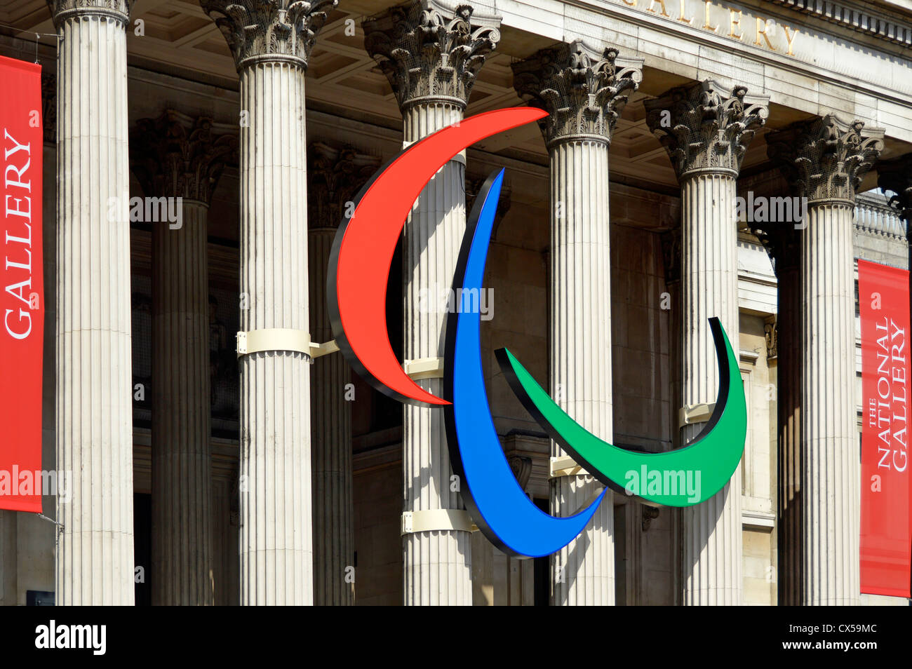 Paralympic red blue & green three agitos in symbol mounted on the columns of the National Gallery colonnade in Trafalgar Square London England UK Stock Photo