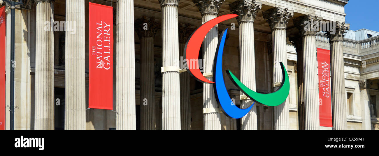 Paralympic red blue & green three agitos in symbol mounted on the columns of the National Gallery colonnade in Trafalgar Square London England UK Stock Photo