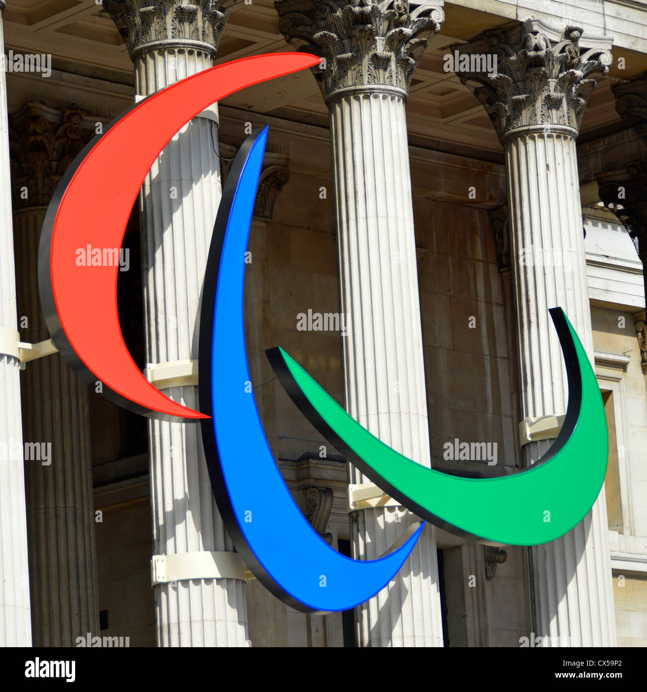 Paralympic symbol of three agitos coloured red blue and green mounted on the columns of the National Gallery in Trafalgar Square London England UK Stock Photo
